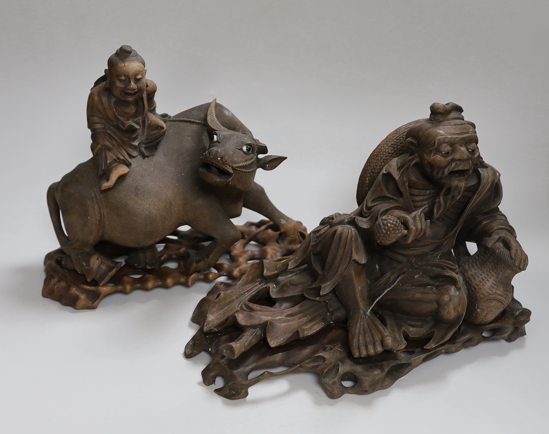 Two Chinese carved hardwood figure groups on stands, early 20th century, largest 30cm long